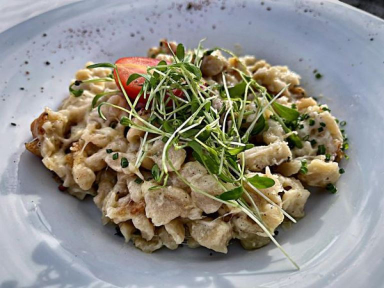 Ein Teller voller Käsespätzle.